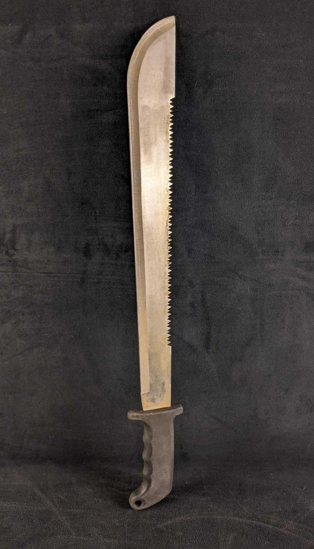 Double Sided Machete Serrated and Plain Blade: Double-Sided Machete Serrated and Plain Blade This machete does not seem to be not too old. The machete has a double edge blade with two different types of edges. One side is a plain edge while the ot