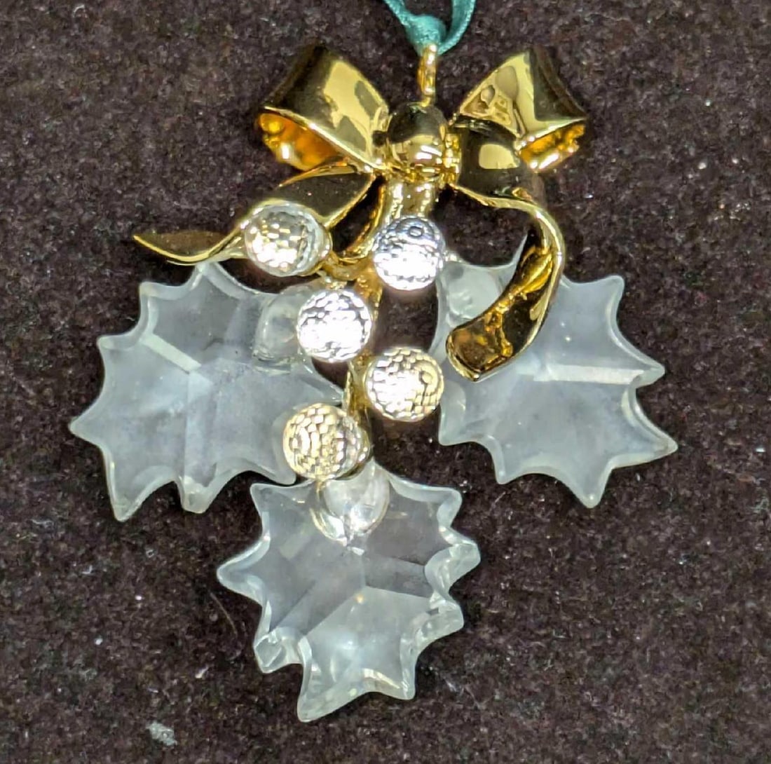 Retired Swarovski Christmas Memories Holly Ornament: Retired Swarovski Christmas Memories Holly Ornament. This comes with the original box that is approx 4" x 1 1/4" x 4" and it weighs 0.17lb. The ornament has no chips or cracks. The box has