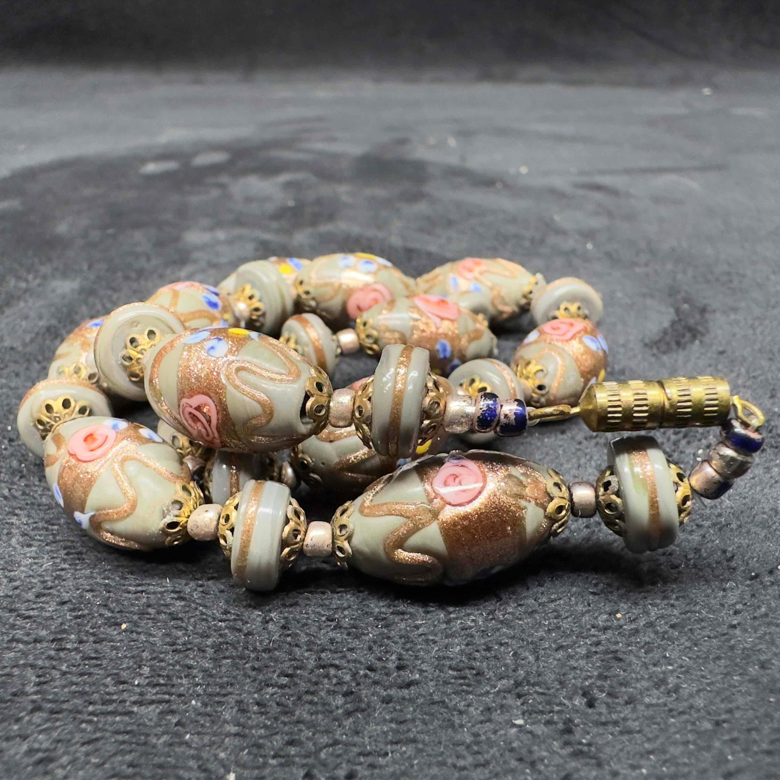 Murano Venetian Art Glass Lamp Work Gray Beaded Necklace B63: Murano Venetian Art Glass Lamp Work Gray Beaded Necklace B63. Necklace with gray colored glass beads with beautiful designs on each. The necklace features copper colored accents. The necklace features