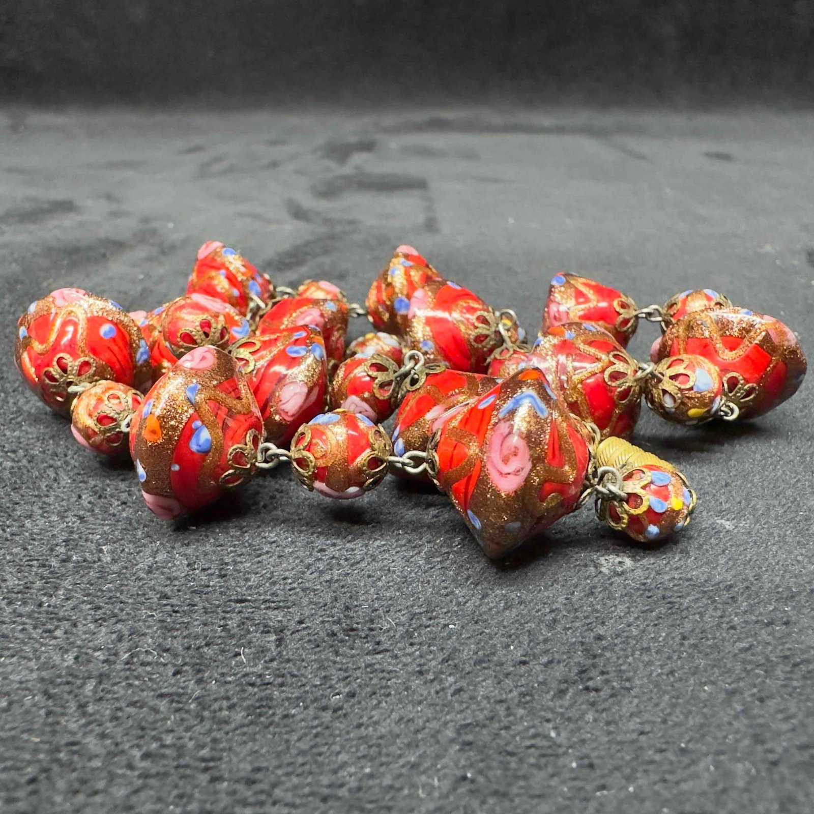 Murano Venetian Glass Lamp Work Bead Red Floral Beaded Necklace B25: Murano Venetian Glass Lamp Work Bead Red Floral Beaded Necklace B25. Necklace with red glass beads with beautiful designs on each. The necklace features floral accents. The necklace features a barrel 