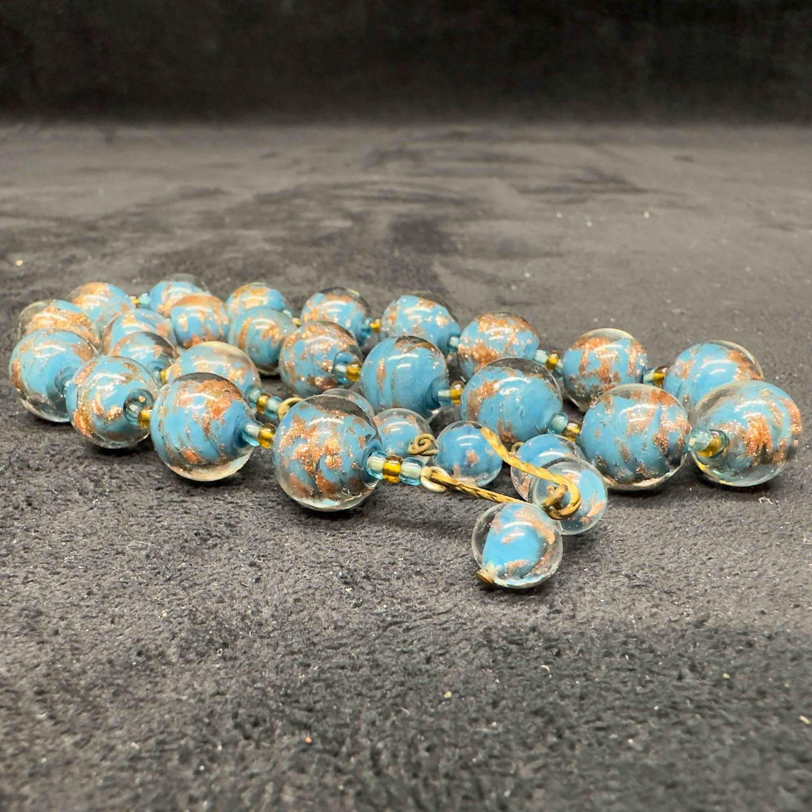 Murano Venetian Lamp Work Glass Copper Aqua Light Blue Round Beaded Necklace B31: Murano Venetian Lamp Work Glass Copper Aqua Light Blue Round Beaded Necklace B31. Necklace with blue colored glass beads with beautiful designs on each. The necklace features floral accents. The neckl
