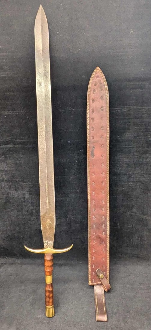 Damascus Steel Sword With Wood Handle: Damascus Steel Sword With Wood Handle. With brass bolster and pommel and leather sheath. Is approx 6 1/4" x1 1/2" x 38 1/2" and it weighs 2.80lbs. Has a company markings on the blade but i