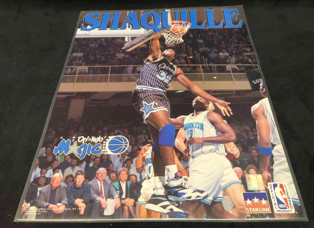 Laminated Photograph Of Shaquille O'Neal Orlando Magic 1993 Starline Inc. By Tim O'Dell NBA Photos: This lot contains laminated photograph of Shaquille O'Neal Orlando Magic 1993 Starline Inc. by Tim O'Dell NBA Photos. The image shoes Shaq going up for a one handed dunk against the Charlotte 