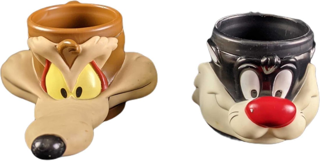 Wile E Coyote & Sylvester The Cat Hard Plastic Mugs: This lot consists of: (1) Wile E Coyote Hard Plastic Mug. Was released by Promotional Partners in 1992. Is approx 6" x 9" x 3 1/2". Is in a good, used condition with some wear, markings a