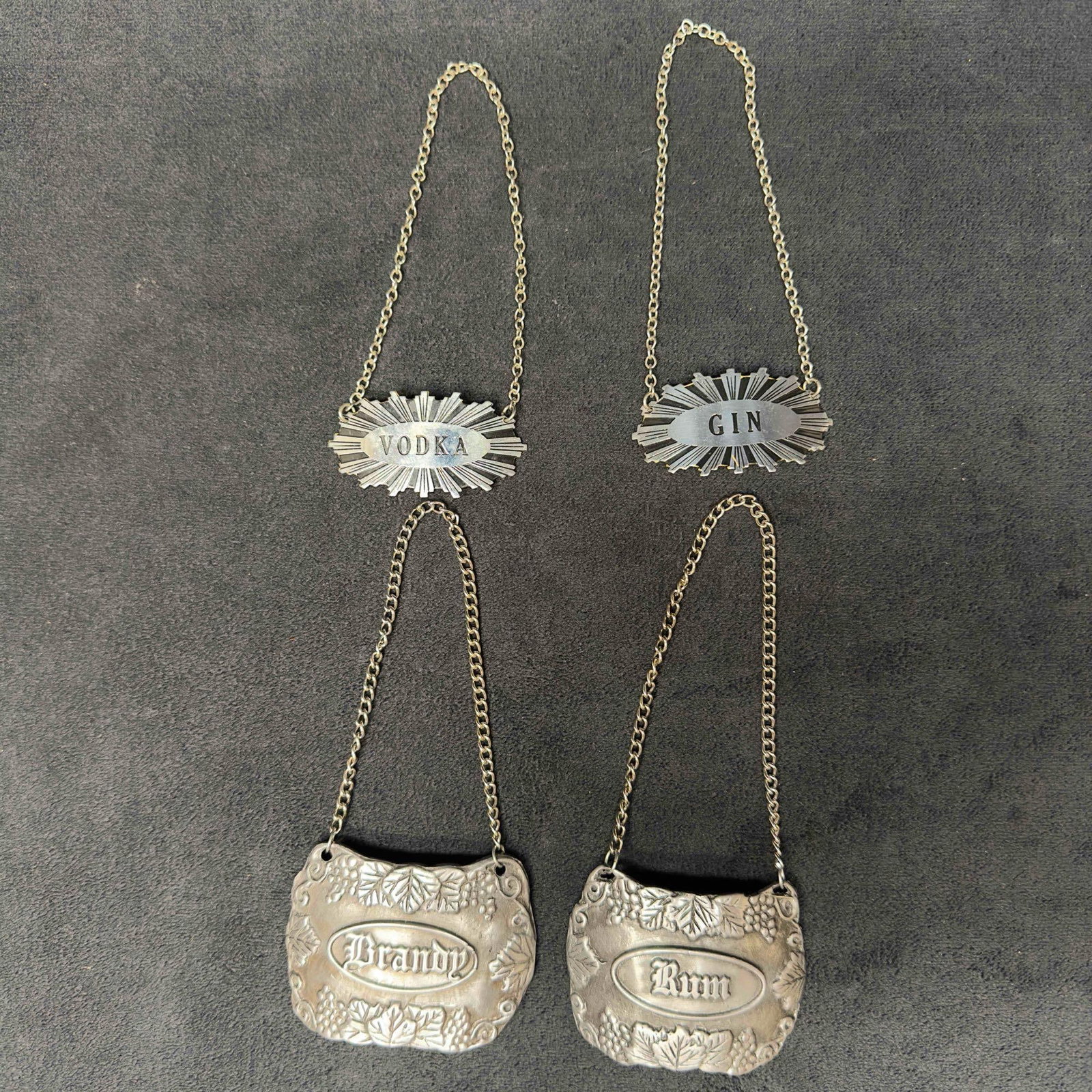 Vintage Liquor Decanter Tags Bacchus Pewter Metal Tag: Vintage Liquor Decanter Tags Bacchus Pewter Metal Tag. This collection of liquor tags include a pewter Brandy and Rum, and a Vodka and Gin metal tag. Bacchus Pewter U.S.A. engraved on two of the tags.