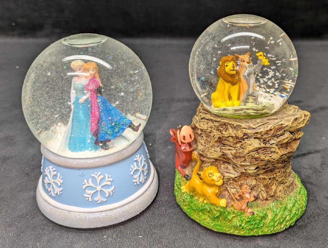 Disney Lion King And Frozen Music Box Snow Globes: Disney Lion King And Frozen Music Box Snow Globes. Both made of resin. This lot includes: (1) Kcare Lion King "Musical Waterball". This is approx 4" x 4" x 6". Simba and Pumbaa ha
