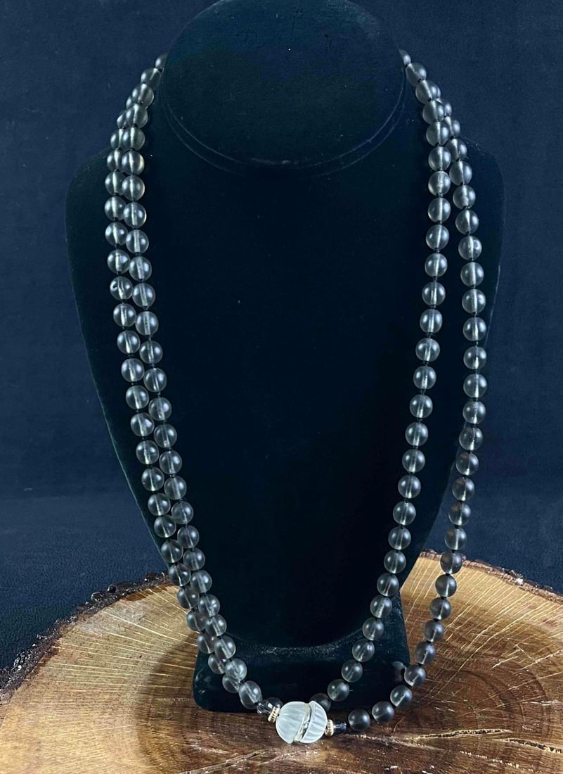 Glass Beaded Necklace Dark Glass Beaded Necklace: Glass Beaded Necklace Dark Glass Beaded Necklace This is an elegant dark frosted glass beaded necklace. The necklace is in good condition with a tiny imperfection on the clear frosted centerpiece bead