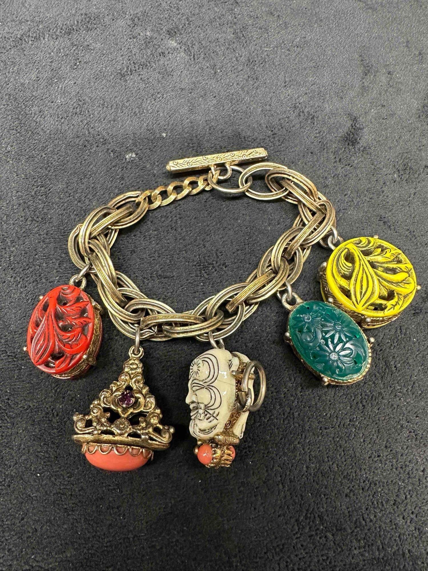 Selro Selini Unmarked Asian Face Charm Gold Tone Bracelet: Selro Selini Unmarked Asian Face Charm Gold Tone Bracelet. Asian themed vintage gold toned bracelet featuring five charms. No identifying markings, unsigned piece. This item is in good pre-owned, prev