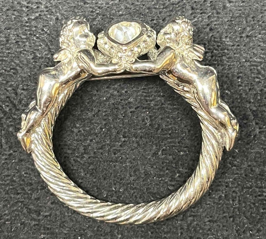Signed Vintage Kirks Folly Silver Tone Cherubs Brooch: This lot contains a Signed Vintage Kirks Folly Silver Tone Cherubs Brooch. The Kirks Folly brand was established in 1979 in New York. The brooch is approx 1 3/4" x 1 3/4" x 3/4" The total weight is ap