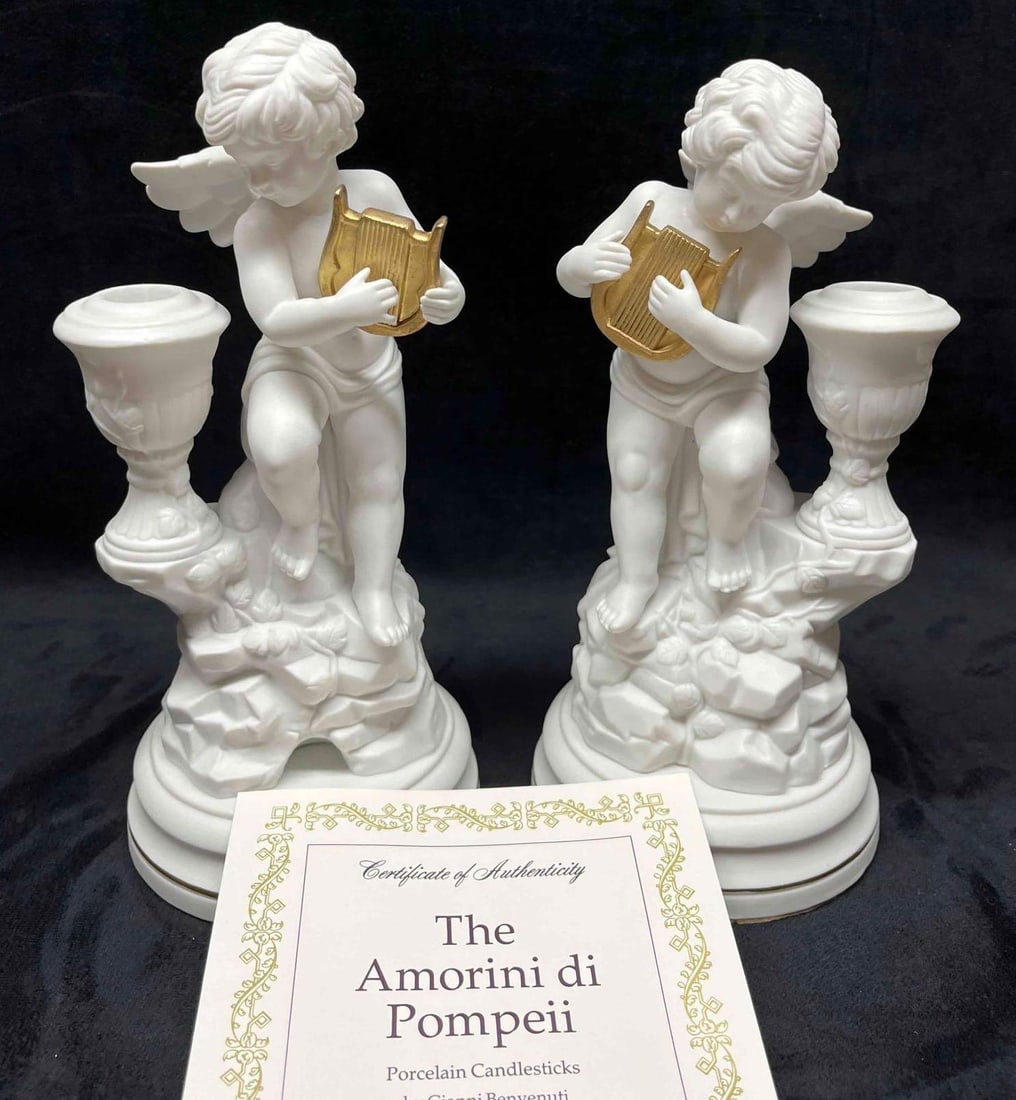 The 1987 Amorini di Pompeii Porcelain Candlesticks By Gianni Benvenuti With COA & Care Instructions: This lot contains The 1987 Amorini di Pompeii Porcelain Candlesticks By Gianni Benvenuti With COA & Care Instructions. Crafted in Korea. In The Franklin Mint. The first Candlestick is approx 4 1/4" x