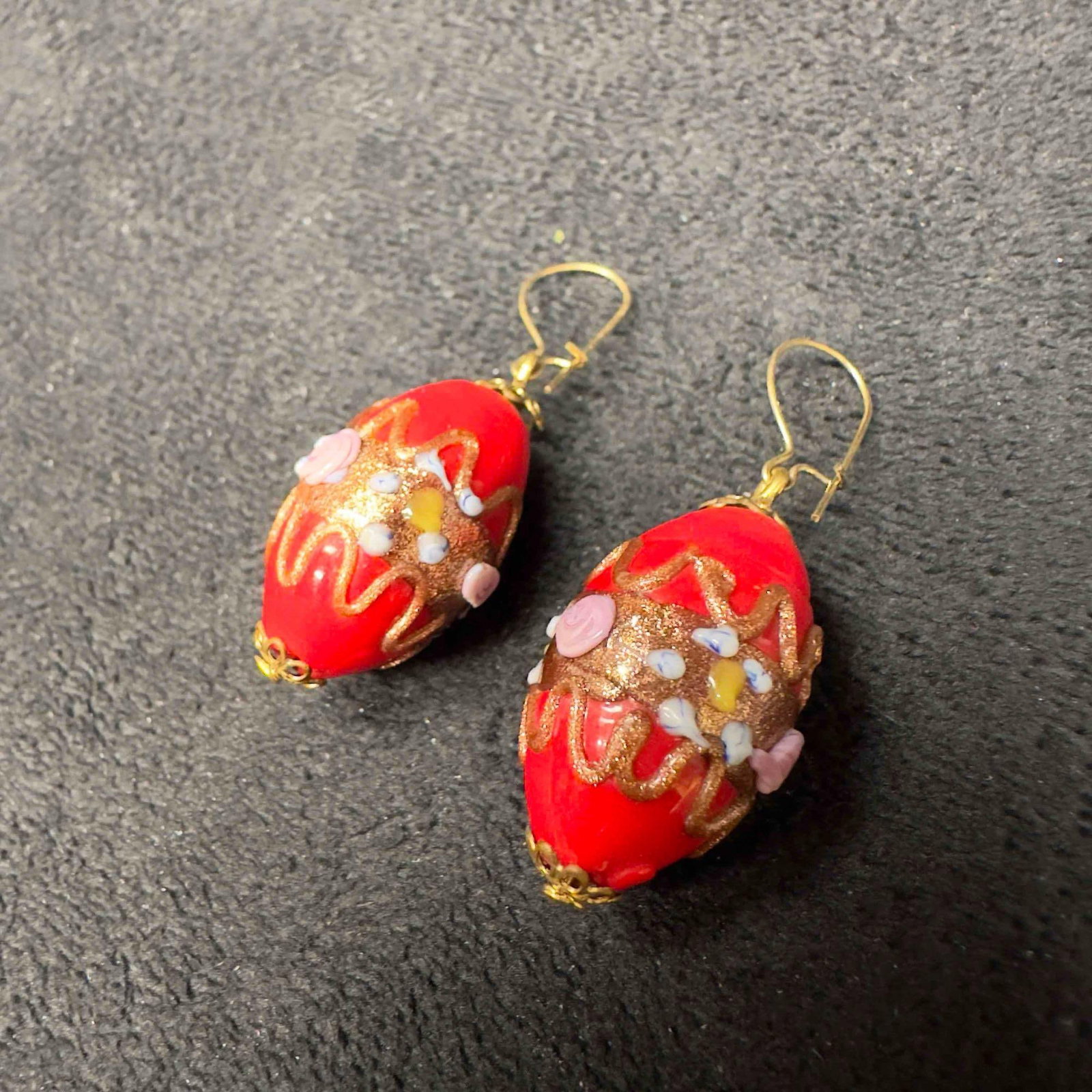 Murano Venetian Art Glass Lamp Work Oval Red Bead Floral Earrings D60: Murano Venetian Art Glass Lamp Work Oval Red Bead Floral Earrings D60. Earrings with red glass beads with beautiful designs on each. The earrings feature copper colored and floral accents. The earring