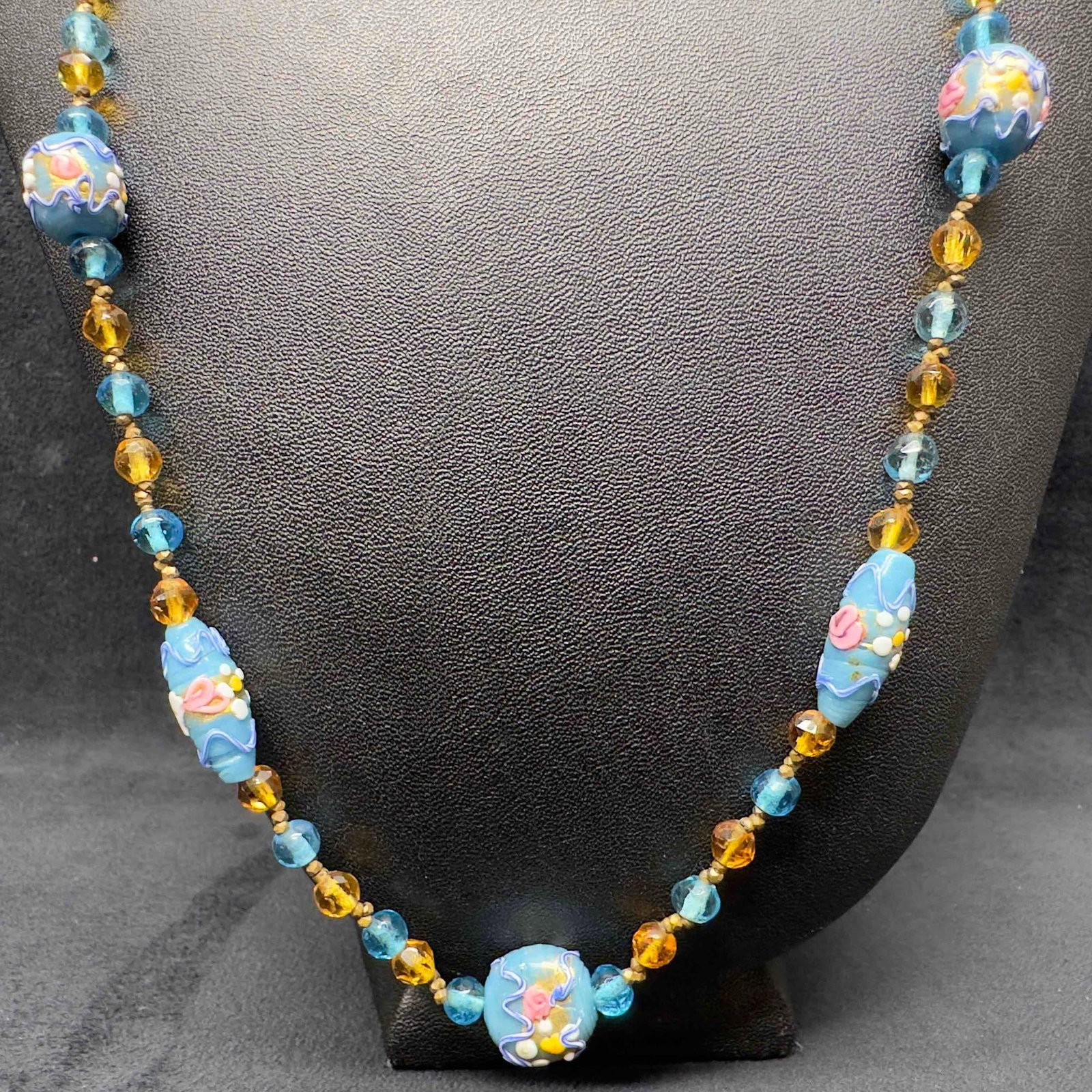 Venetian Murano Lamp Work Art Glass Bead Blue Floral Beaded Necklace C43: Venetian Murano Lamp Work Art Glass Bead Blue Floral Beaded Necklace C43. Necklace with blue colored glass beads with beautiful designs on each. The necklace features floral accents. This item is in g