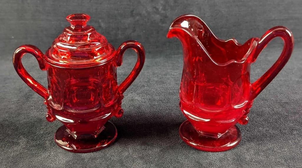Two Fostoria Argus Ruby Glass Sugar Bowl And Creamer: Two Fostoria Argus Ruby Glass Sugar Bowl With Lid And Creamer. The "Argus" design was released from 1964 to 1982. The Sugar Bowl is approx 6" x 3 1/4" x 6". The creamer is approx 5