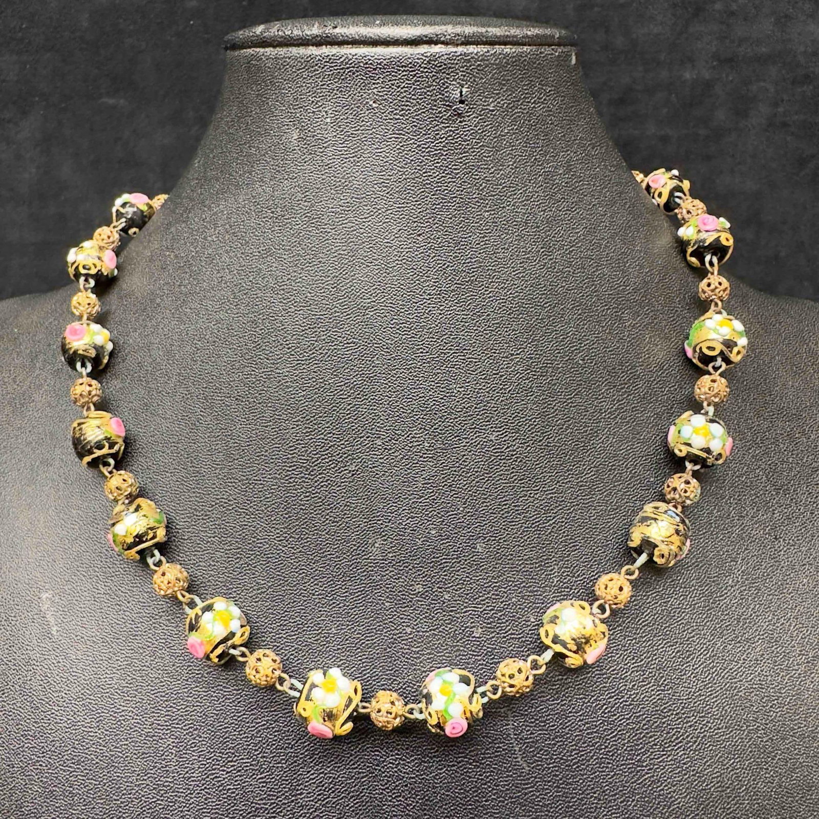 Venetian Murano Glass Lamp Work Black Floral Design Round Bead Necklace: Venetian Murano Glass Lamp Work Black Floral Design Round Bead Necklace. Necklace with black glass beads with beautiful hand painted floral designs on each. The necklace features gold colored accents.