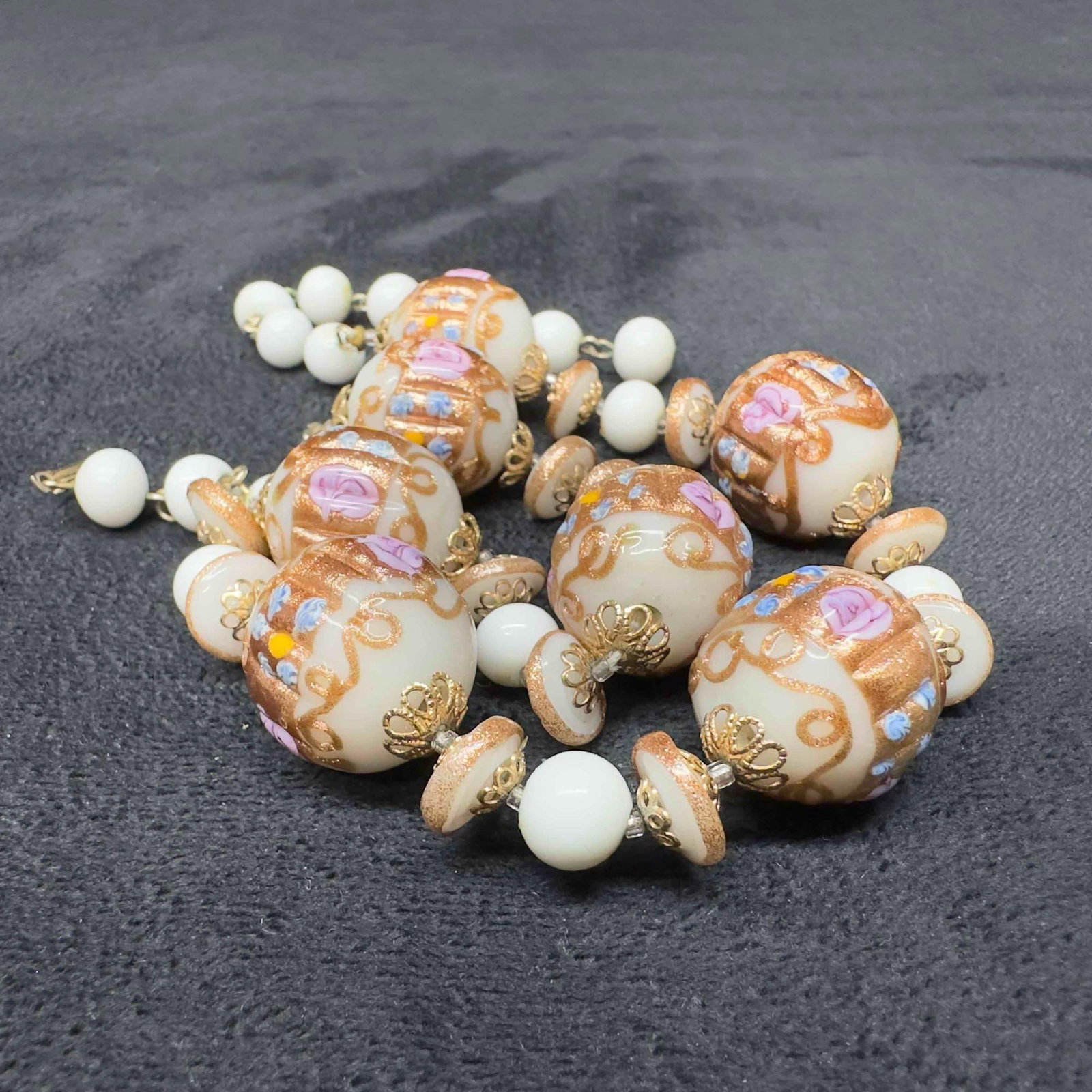 Venetian Murano Lamp Work Glass White Bead Fiorato Floral Beaded Necklace A95: Venetian Murano Lamp Work Glass White Bead Fiorato Floral Beaded Necklace A95. Necklace with white glass beads with beautiful designs on each. The necklace features copper and floral accents. The neck