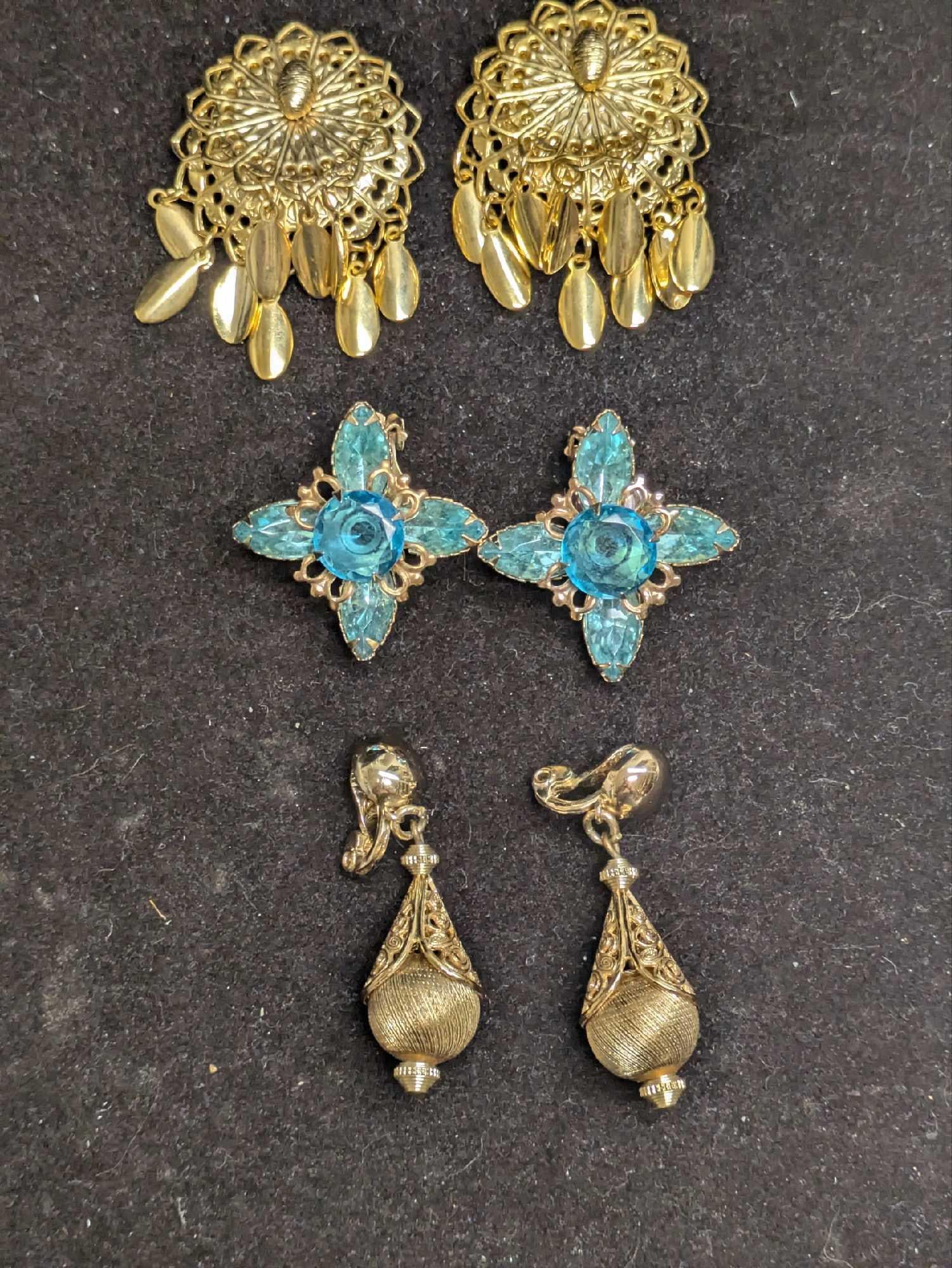 3 Sets Of Gold Tone Clip On Earrings Monet Southwest Style: 3 Sets Of Gold Tone Clip On Earrings Monet Southwest Style. This lot includes: (1) Set Of Southwest Gold Tone Style Dangle Clip On Earrings. This is approx 1 1/4" x 1/4" x 1 1/4". (1) Set 