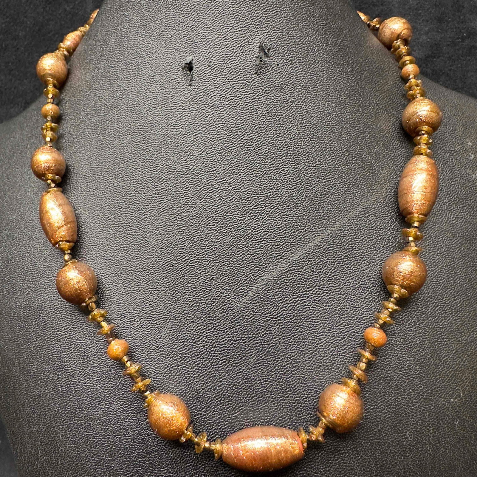 Murano Venetian Lamp Work Art Glass Bronze Copper Beaded Necklace G24: Murano Venetian Lamp Work Art Glass Bronze Copper Beaded Necklace G24. Necklace with bronze colored glass beads with beautiful designs on each. The necklace has a copper colored accents. The necklace 