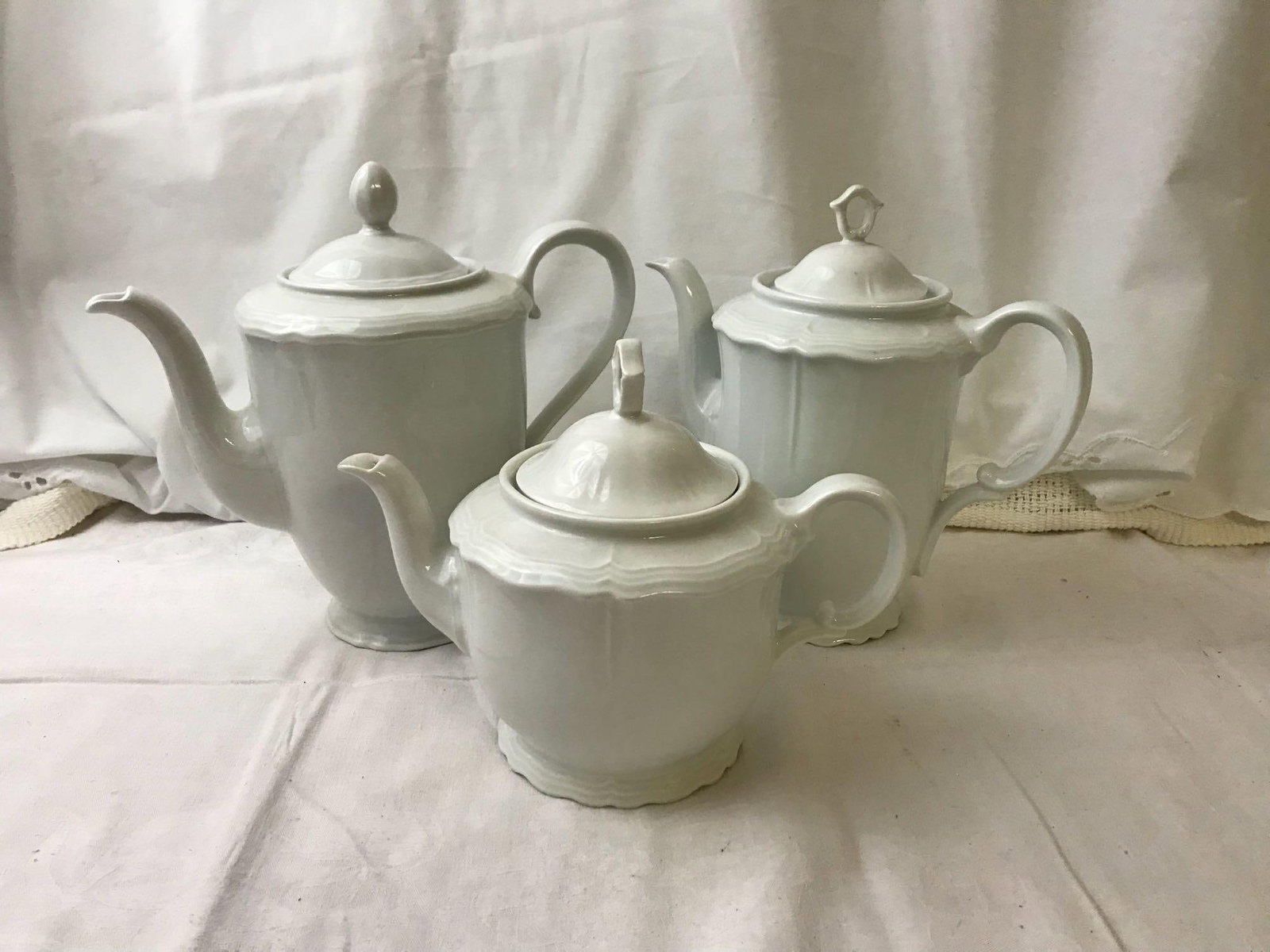 Rhinekrone Bavaria Tea & Coffee Pots: Vintage Rhinekrone Bavaria Tea & Coffee Pots; Made of porcelain, each are a simple white baroque style and vary in size. The coffee pots measure at approximately 10" H x 10" D and and the teapot 