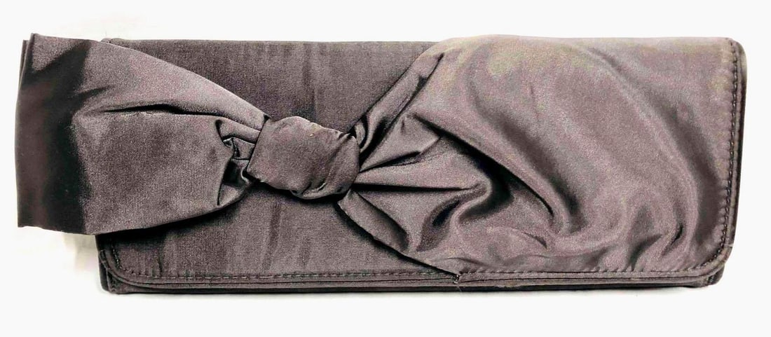 Steve Madden Bow Purse: This lot contains a Steve Madden Bow Purse. It is approx 5 1/2" x 14 1/4" and it weighs about 0.5lbs. Body is 100% Polyester and the trim is NIL.Overall the purse is in good used condition with some l