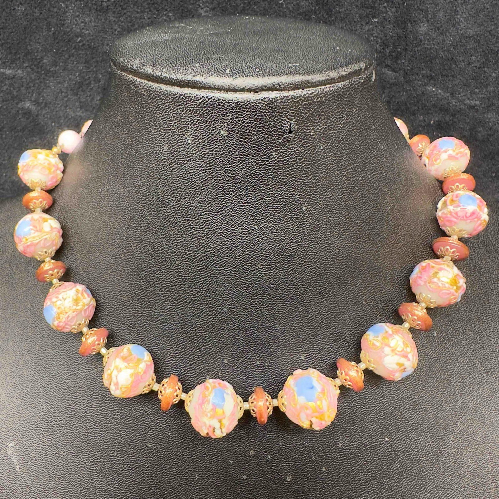Murano Venetian Art Glass Lamp Work Pink White Round Beaded Necklace C64: Murano Venetian Art Glass Lamp Work Pink White Round Beaded Necklace C64. Necklace with pink colored glass beads with beautiful designs on each. The necklace features white colored accents. The neckla