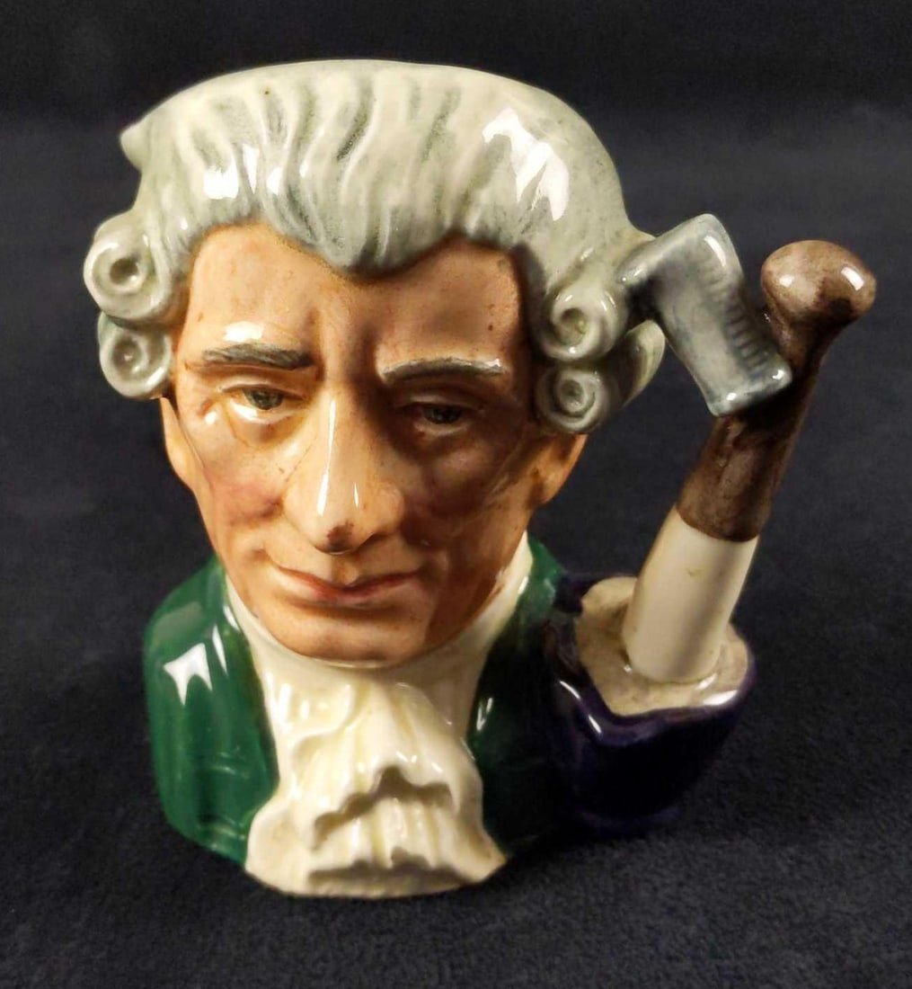 Retired Royal Doulton Apothecary Character Jug: Apothecary D6574 (green coat with white cravat; white wig). Designed by Max Henk. Series: Characters From Williamsburg, issued 1963 – 1983. Is approx 4" x 2 1/2" x 4" and it weighs 0.35lb. Is in goo