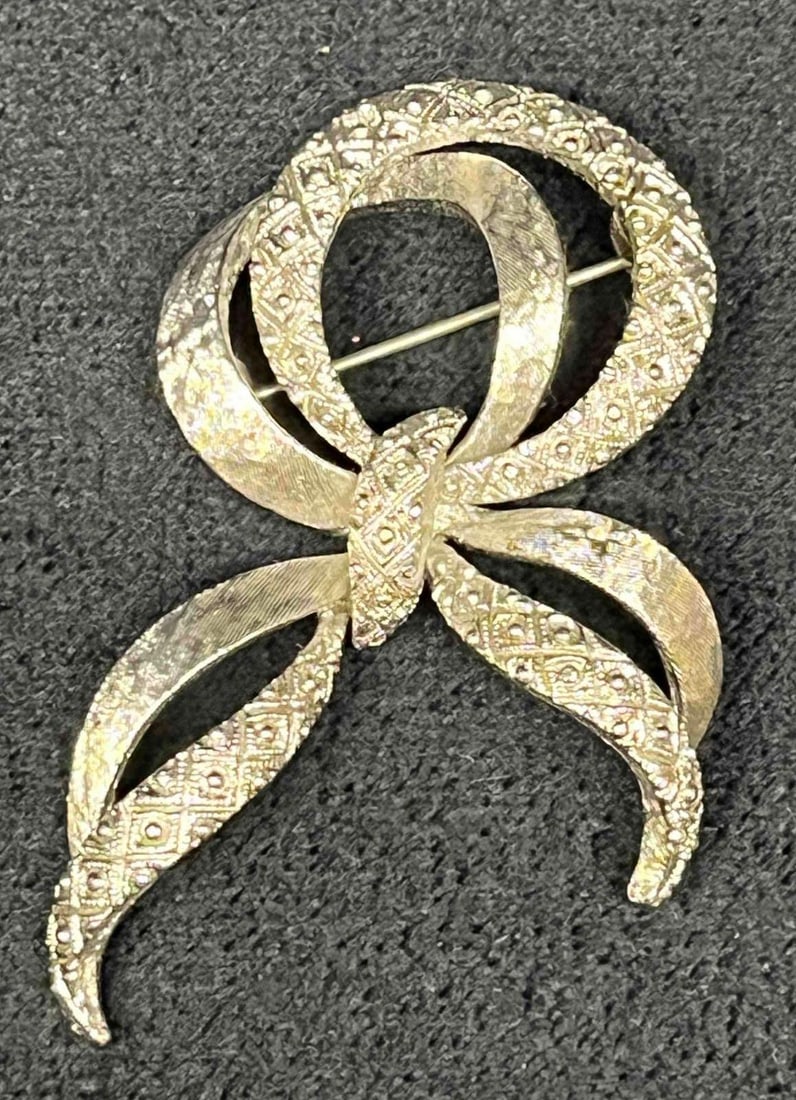 Signed Vintage Monet Silver Tone Ribbon Brooch: This lot contains a Signed Vintage Monet Silver Tone Ribbon Brooch. It is approx 2 1/4" x 1 1/2" x 1/2". Total weight is 0.4oz. Overall the vintage Monet Brooch is in excellent pre owned condition wit