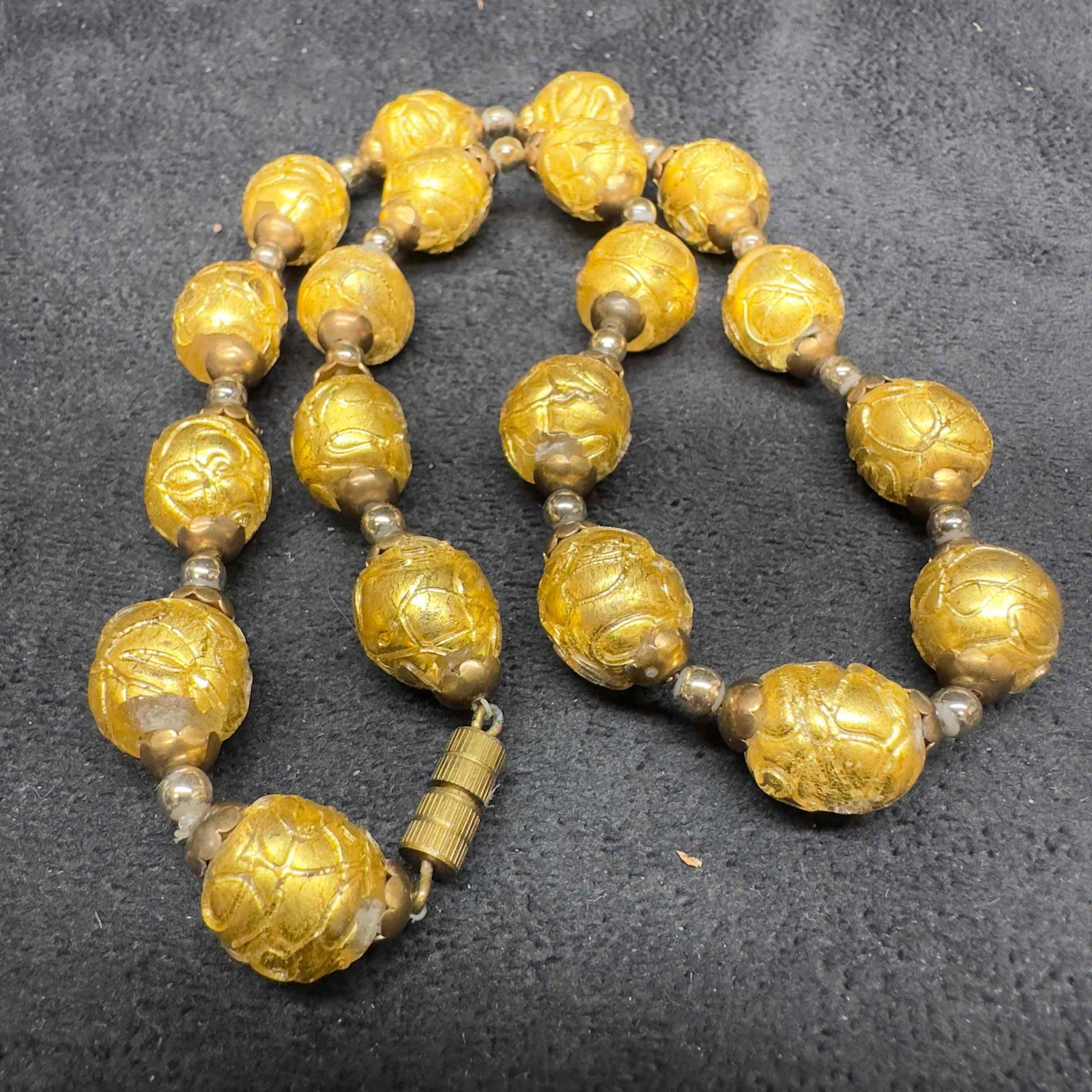 Murano Venetian Lamp Work Glass Gold Bead Beaded Necklace A51: Murano Venetian Lamp Work Glass Gold Bead Beaded Necklace A51. Necklace with gold colored glass beads with beautiful designs on each. The necklace features a barrel screw clasp. This item is in good p