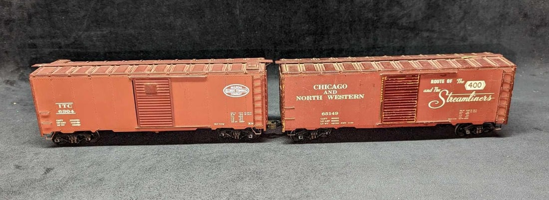 2 O Scale Distressed Illinois & Chicago Boxcars: 2 O Scale Distressed Illinois & Chicago Boxcars. This lot includes: (1) Chicago And North Western 65149 "Route Of The 40 And The Streamliners" O Scale Boxcar. This is approx 11 1/2" x 