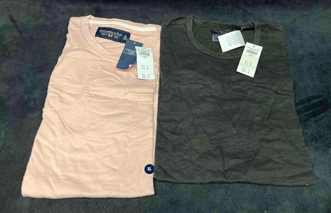 Two Mens Abercrombie T-Shirts Large & XLarge With Tags: This lot contains Two Mens Abercrombie T-Shirts Large & XLarge With Tags. The shirts are each approx 6 1/2" x 11" x 1" folded and together they weigh about 0.6lbs. The Abercrombie T-Shirts are in