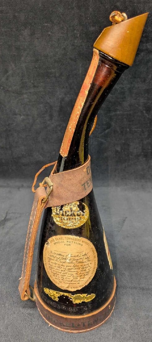 George Dickel Tennessee Whiskey Souvenir Bottle: George Dickel Tennessee Whiskey Souvenir Bottle. The bottle, created in 1962, features a leather harness and is approx 6 1/2" x 5" x 15" and it weighs 2.55lbs. These were originally sold to