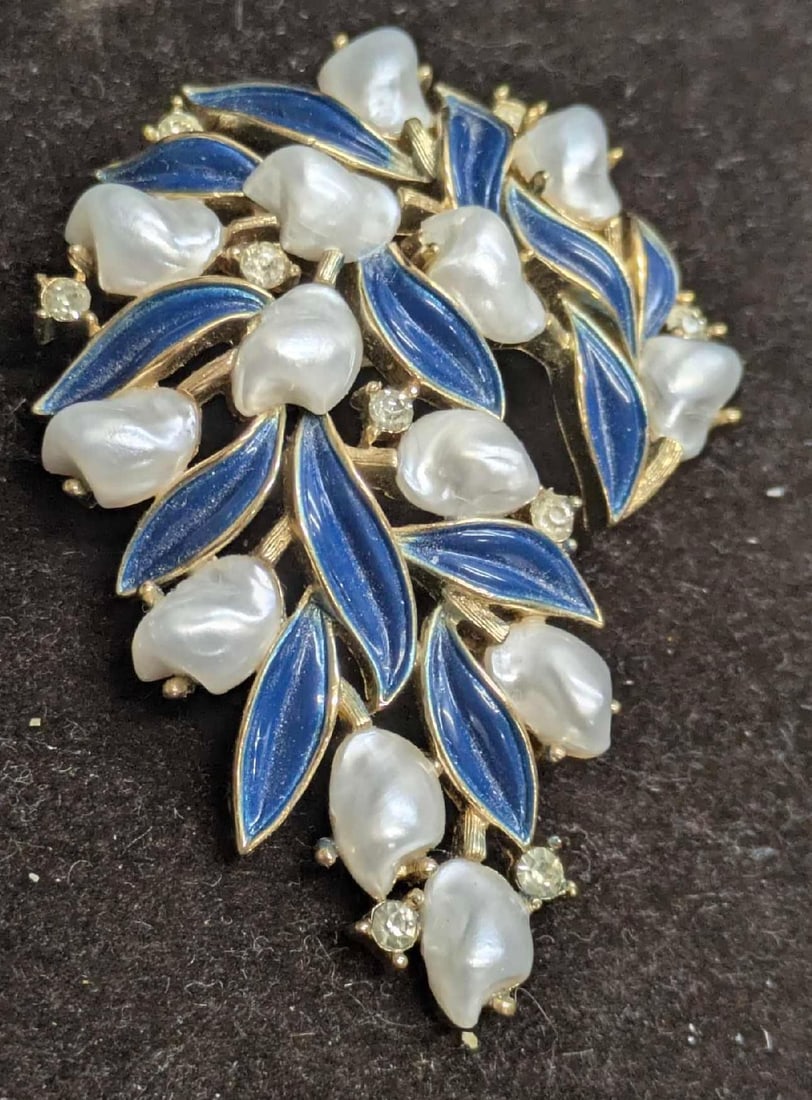 Rare Trifari Baby Tooth Pearls And Blue Enameled Leaves Brooch: Rare Trifari Baby Tooth Pearls And Blue Enameled Leaves Brooch. On gold plated metal with clear chatons. This is approx 2 3/8" x 1 3/4" x 1/2" and it weighs 0.04lb. 