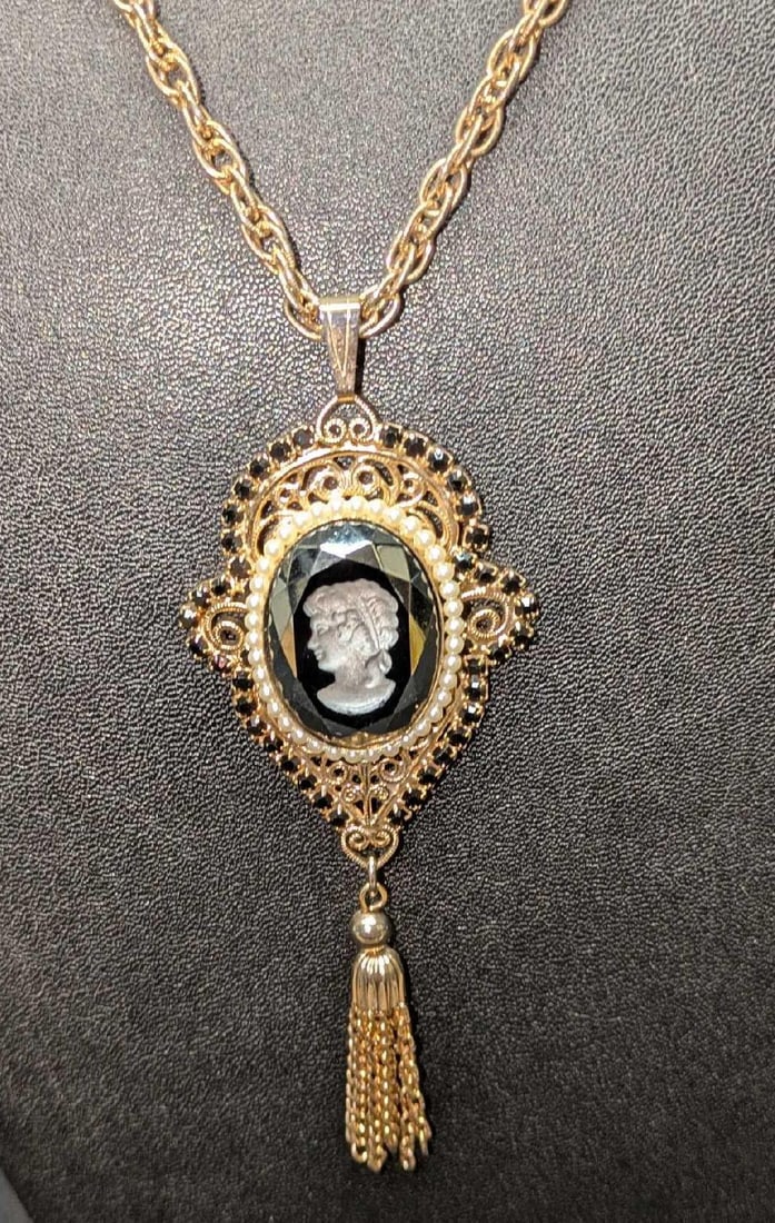 Vintage Glass Cameo Gold Tone Necklace With Tassel: Vintage Glass Cameo Gold Tone Necklace With Tassel. Pendant has a black glass backdrop. This is approx 21" and the pendant is approx 1 5/8" x 1/4" x 3 1/2". 