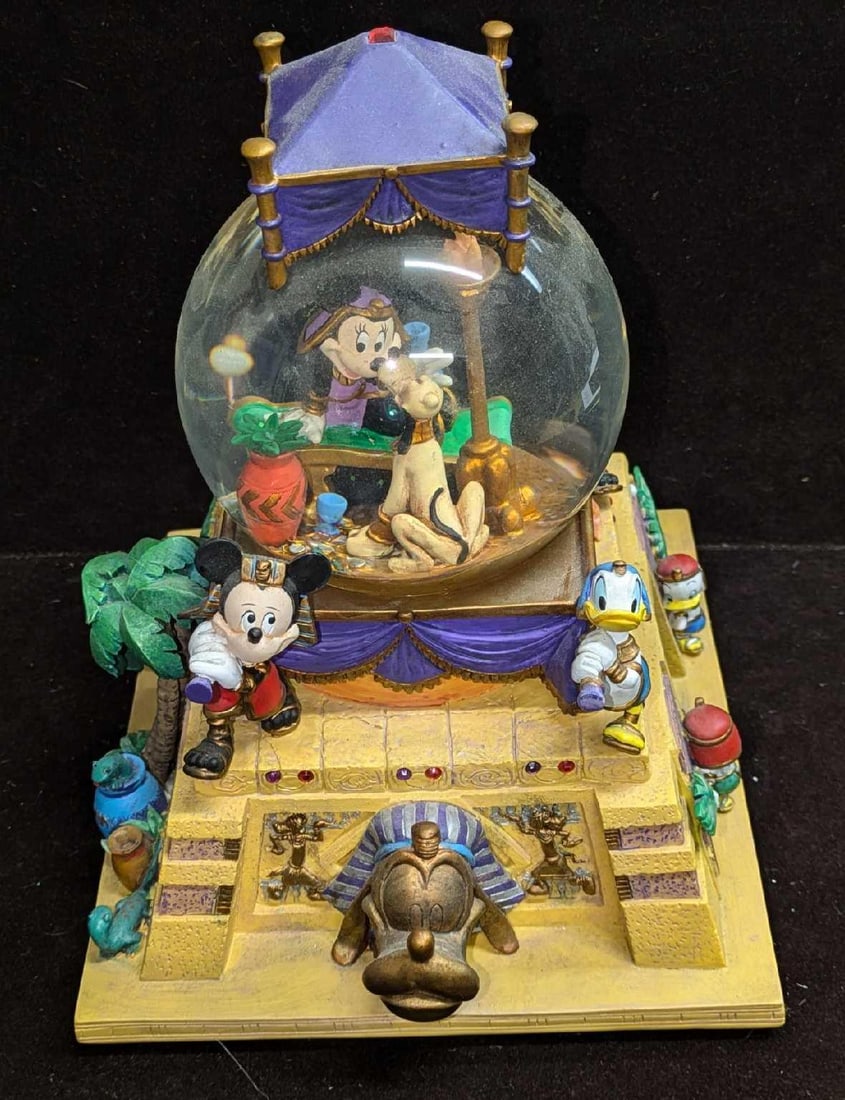 Disney Musical Water Globe Queen Of The Nile: Disney Musical Water Globe Queen Of The Nile. This resin water globe plays "Minnie's Yoo Hoo". The light up feature requires two AA batteries (Not included) and is untested. The water globe is approx 