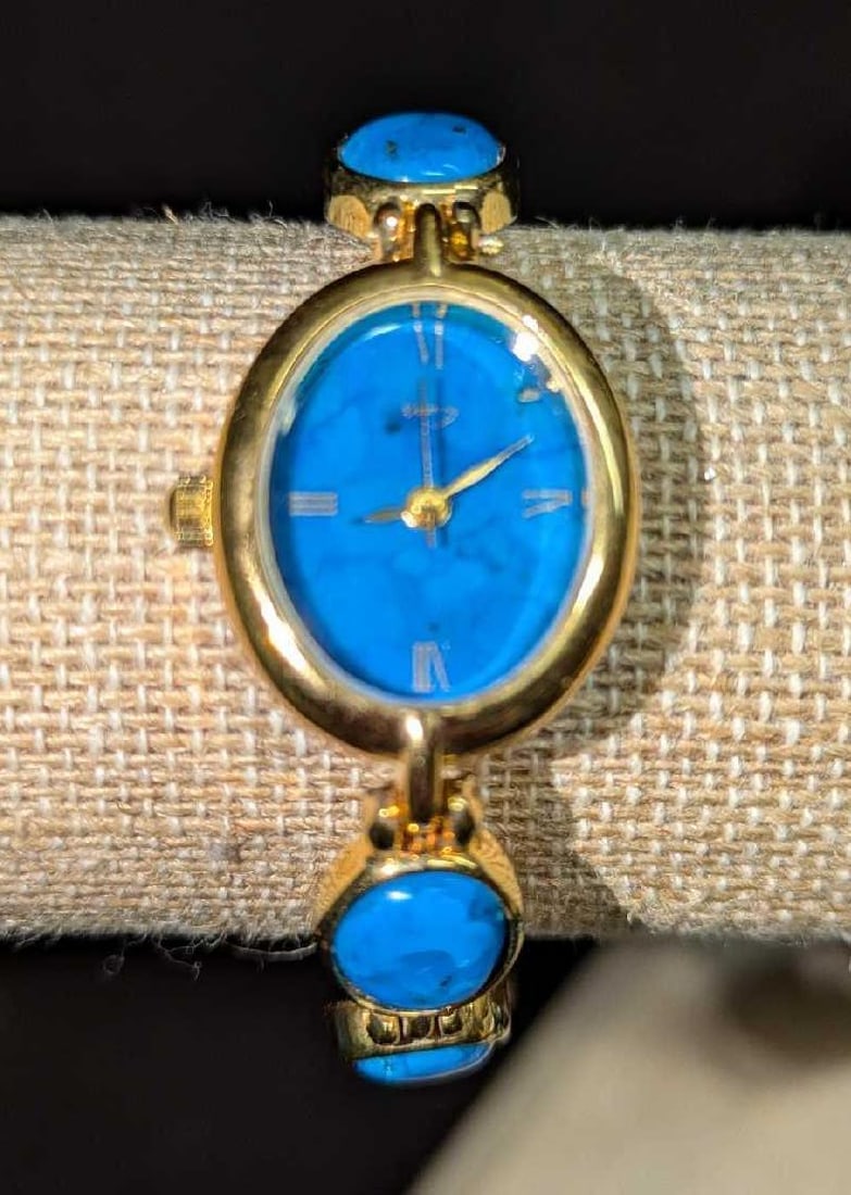 Vintage Ladies Gold Tone Faux Turquoise Watch: Vintage Ladies Gold Tone Faux Turquoise Watch. There is a maker's logo on the face of the watch but we were unable to read the logo. This is approx 3/4" x 1/4" x 7 3/4" and it weighs 0.06lb. The watch