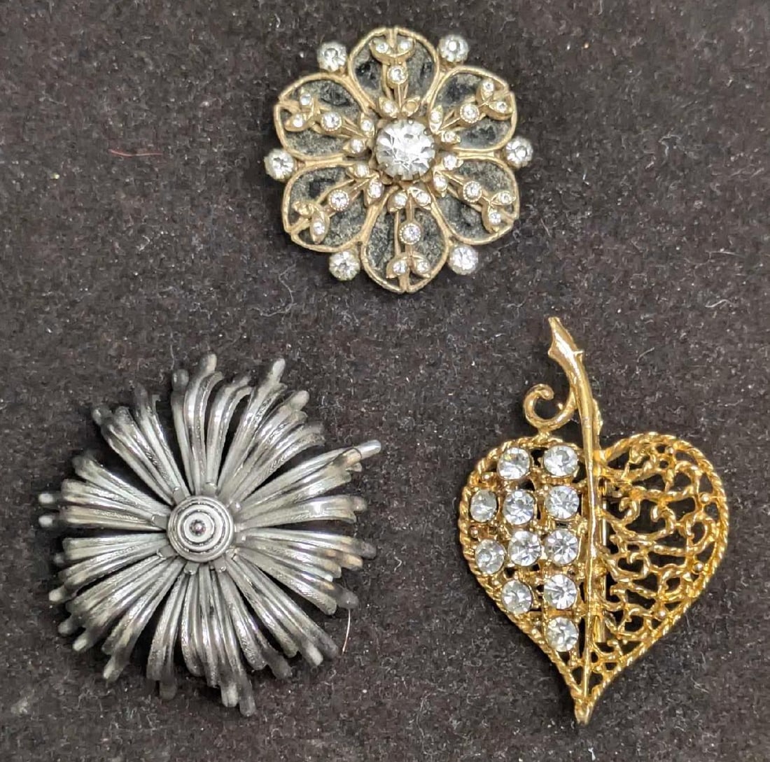 3 Vintage Floral And Apple Heart Pin Brooches: 3 Vintage Floral And Apple Heart Pin Brooches. This lot includes: (1) Coro Clear Rhinestones Floral Brooch Pin. This is approx 1 3/8" x 1 3/8" x 1/2". (1) Giovanni Silver Tone Flower Broo