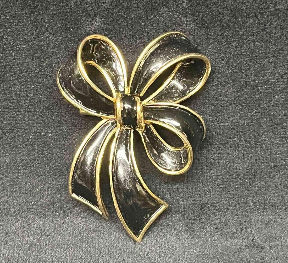 Vintage Signed Crown Trifari Gold Tone & Black Enamel Bow Brooch: This lot contains a Vintage Signed Crown Trifari Gold Tone & Black Enamel Bow Brooch. It is approx 2 1/4" x 1 1/2" x 3/4". Total weight is 0.7oz. Overall the Vintage Crown Trifari Brooch is in excelle