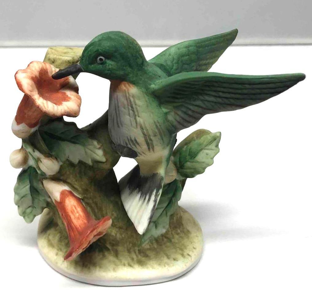 Vintage Lefton Porcelain Humming Bird Figurine With Trumpet Flowers: This lot contains a vintage Lefton porcelain humming bird figurine with trumpet flowers. The bottom of the figurine is marked with a Lefton sticker and logo that states "trade mark exclusives Jap