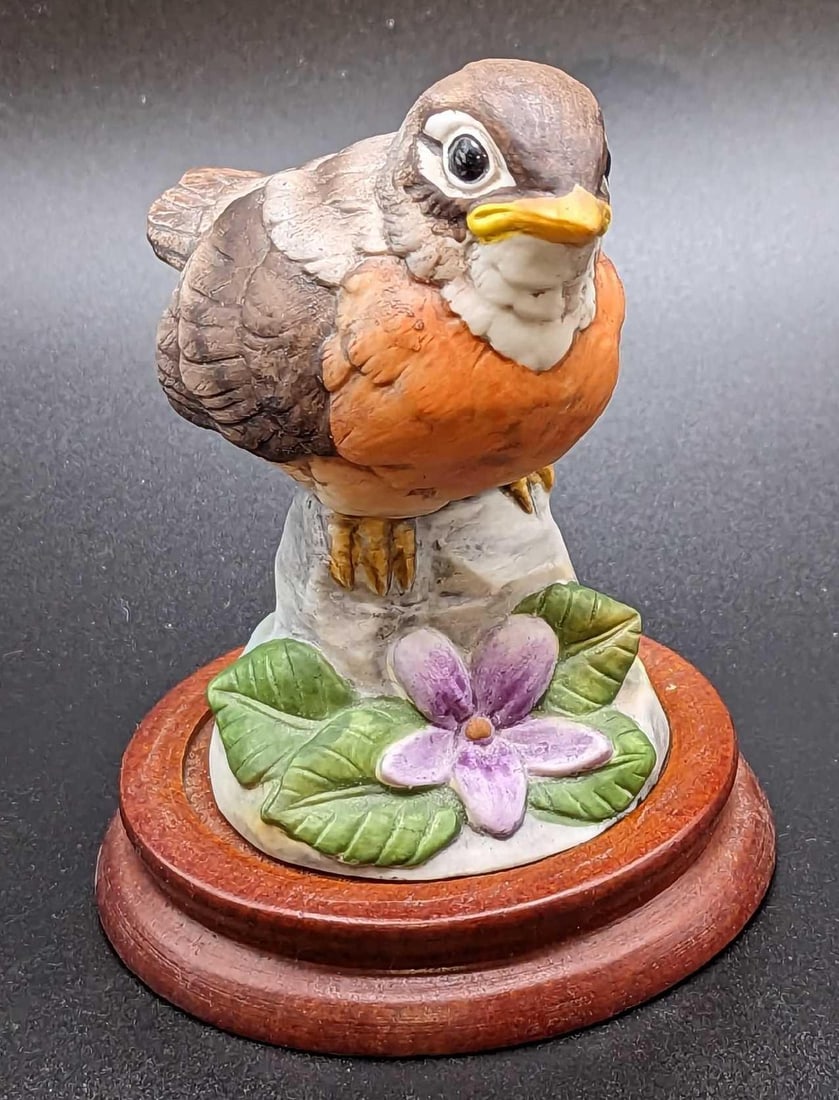 Retired Andrea By Sadek Robin Figurine: Retired Andrea By Sadek Robin Figurine. The figurine is approx 3" x 2 1/2" x 3 1/4". The display stand is approx 3 1/4" x 3 1/4" x 3/4". The total weight is 0.28lb. The display stand has some we