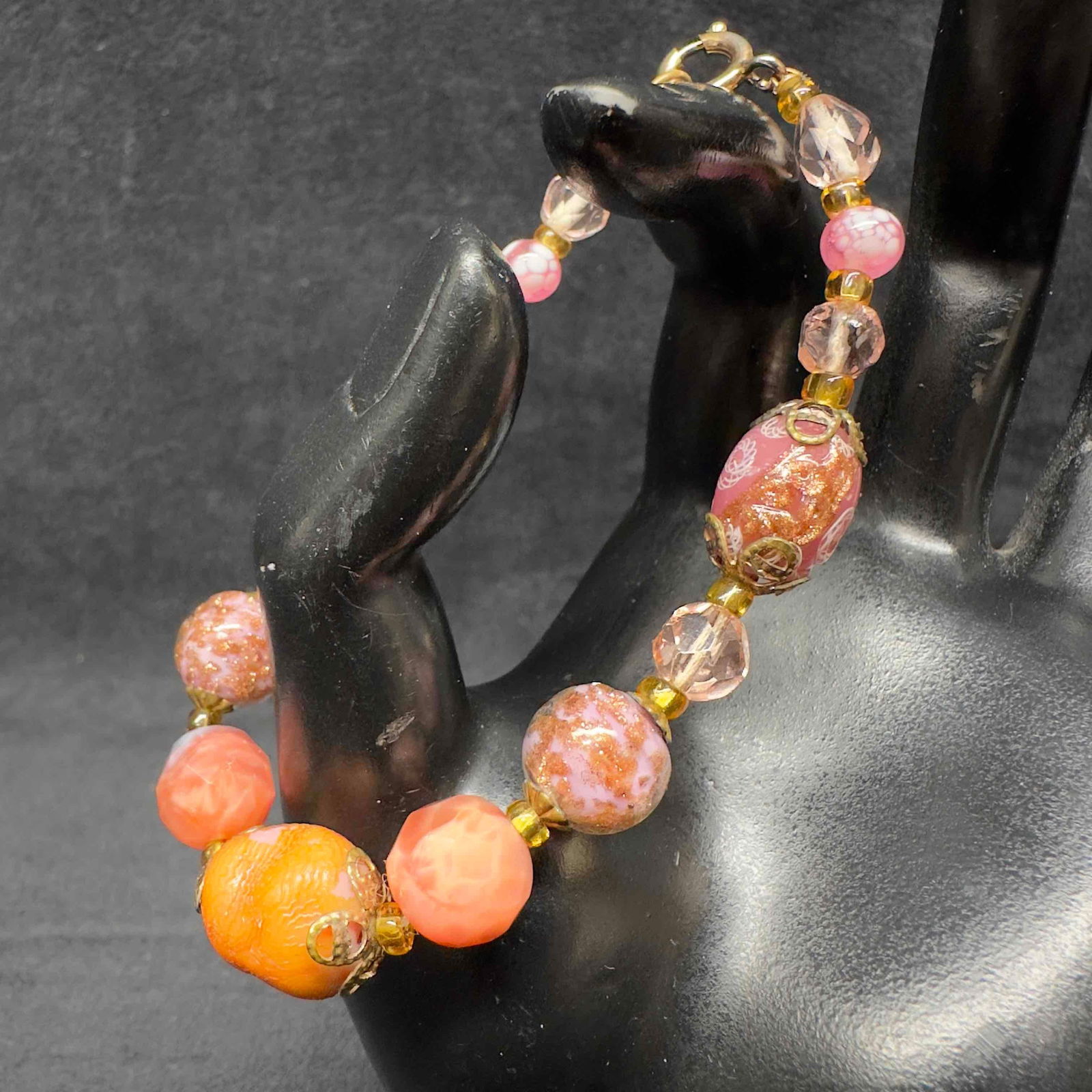 Venetian Murano Lamp Work Glass Copper Accent Pink Colored Beaded Bracelet I3: Venetian Murano Lamp Work Glass Copper Accent Pink Colored Beaded Bracelet I3. Bracelet with pink colored glass beads with beautiful designs on each. The bracelet features a spring ring clasp closure.