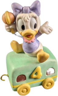 Disney Baby Daisy Duck Porcelain Train: Disney Baby Daisy Duck Porcelain Train. Baby Daisy waves while sitting on top of a train cabin. This is approx 2 1/2" x 1 1/4" x 3 1/2" and it weighs under one pound at 0.17lb. The train is in a good,