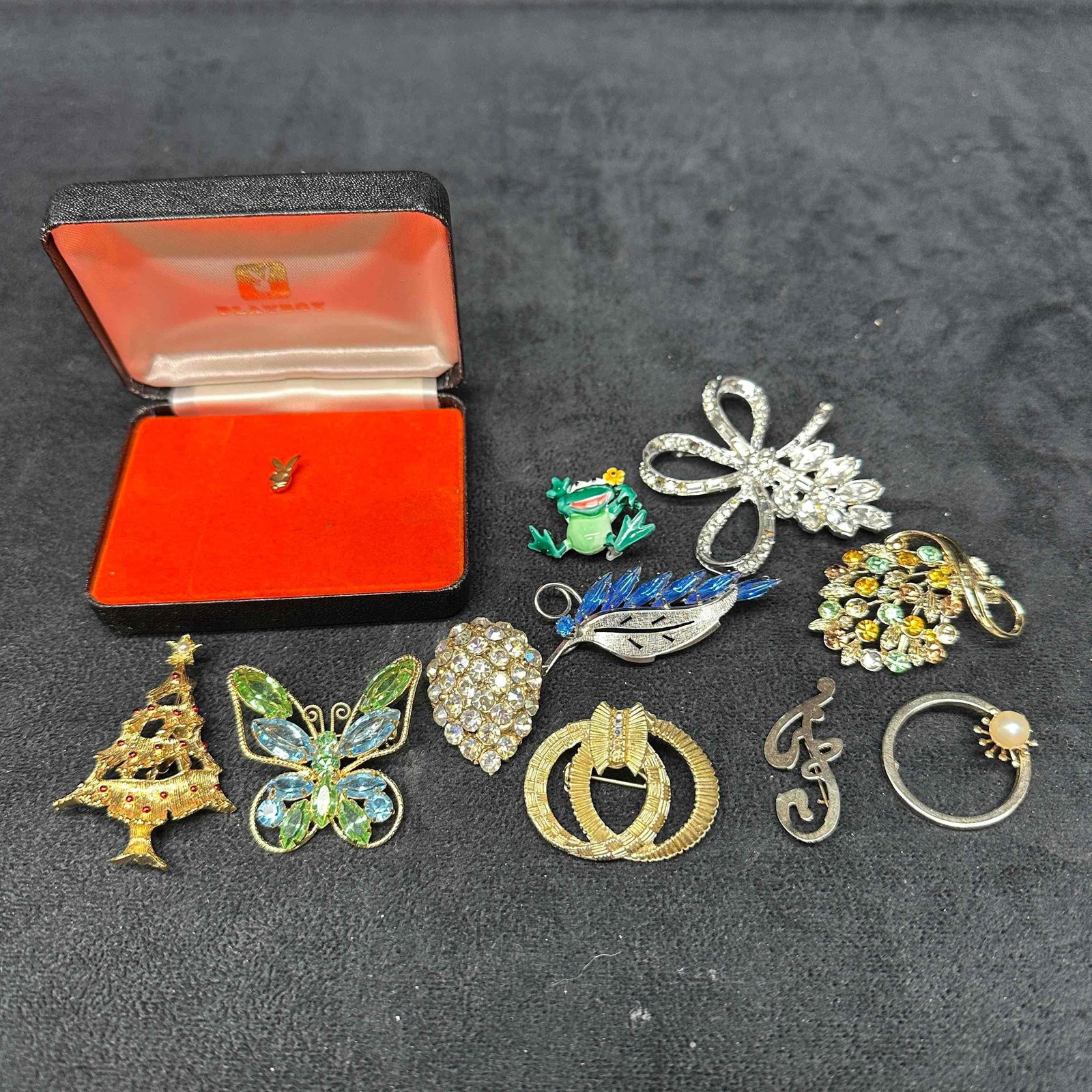 Playboy Vintage Costume Jewelry Brooch Rhinestone Set Lot of Eleven: These brooch costume jewelry pieces showcase beautiful colors and designs. Some materials have been marked. A few of the brooches features rhinestones. One brooch is missing closure. Playboy pin comes