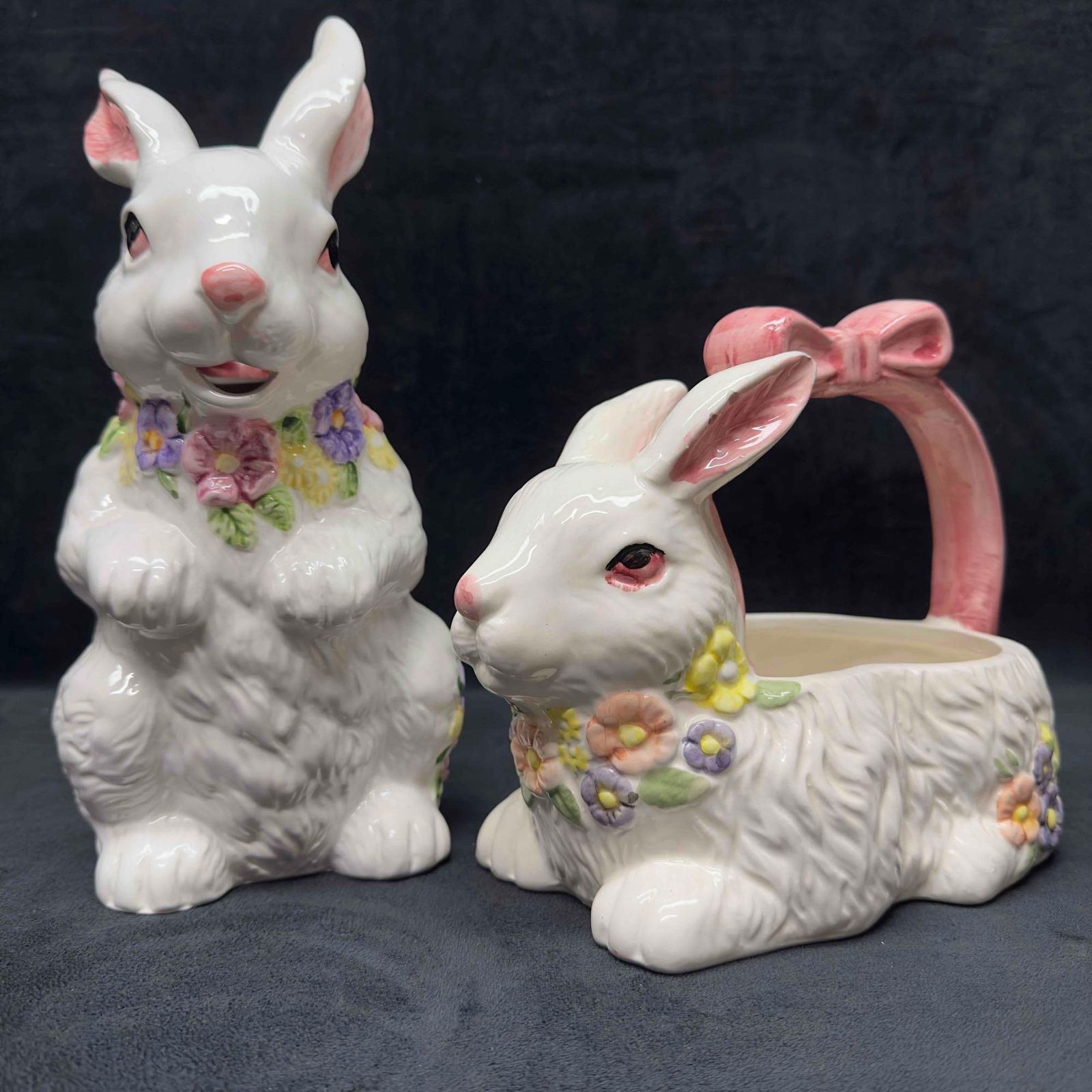 Porcelain Easter Bunny Rabbit Pitcher and Basket Napkin Holder Set: Porcelain Easter Bunny Rabbit Pitcher and Basket Napkin Holder Set. The set has a floral design with a pink ribbon handle. Porcelain pieces made in China and Taiwan. These items are in good pre-owned,