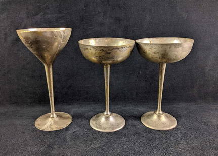 Three Silver Plated Stemmed Goblets: Three Silver Plated Stemmed Goblets These silver-plated goblets have some tarnish. two are a pair. One goblet has a crack on its rim. This lot is in overall decent condition.  These goblets are a cool
