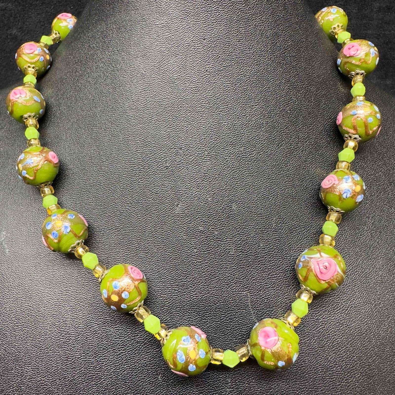 Venetian Murano Art Glass Lamp Work Green Floral Pink Blue Beaded Necklace E14: Venetian Murano Art Glass Lamp Work Green Floral Pink Blue Beaded Necklace E14. Necklace with green colored glass beads with beautiful hand painted designs on each. The necklace features pink and blue