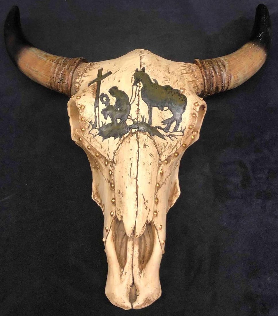 Resin Wall Sculpture Of Tooled Bull Skull: This lot contains a resin wall sculpture of a tooled bull skull. The skull is designed with gold beads and the image of a man and horse visiting a grave. Made in China. It is approx 12" x 11 3/4" x 4"