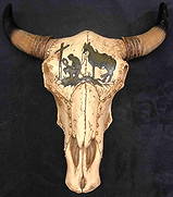Resin Wall Sculpture Of Tooled Bull Skull: This lot contains a resin wall sculpture of a tooled bull skull. The skull is designed with gold beads and the image of a man and horse visiting a grave. Made in China. It is approx 12" x 11 3/4" x 4"