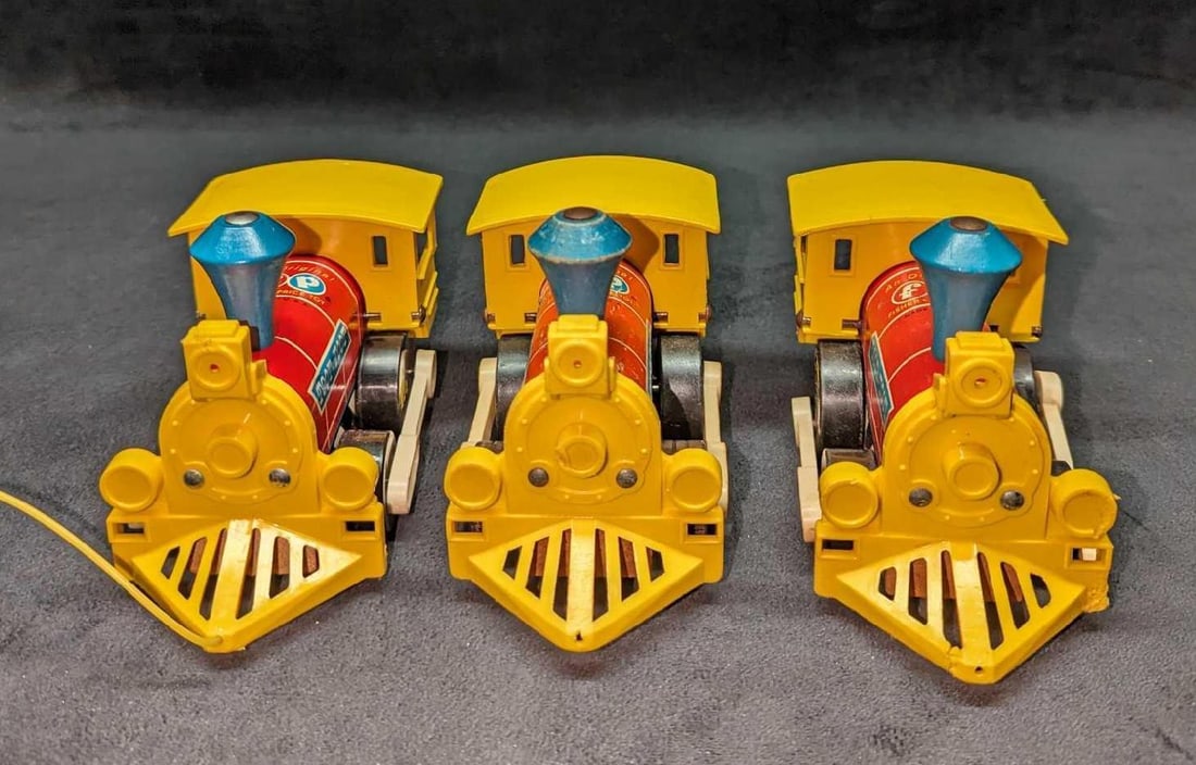3 Vintage Fisher Price Toot-Toot Toy Trains: 3 Vintage Fisher Price Toot-Toot Toy Trains. Each is approx 6" x 3 1/4" x 4". The total weight is 1.16lb. The trains have wear, markings and scratches. Only one still has its original pull string. One