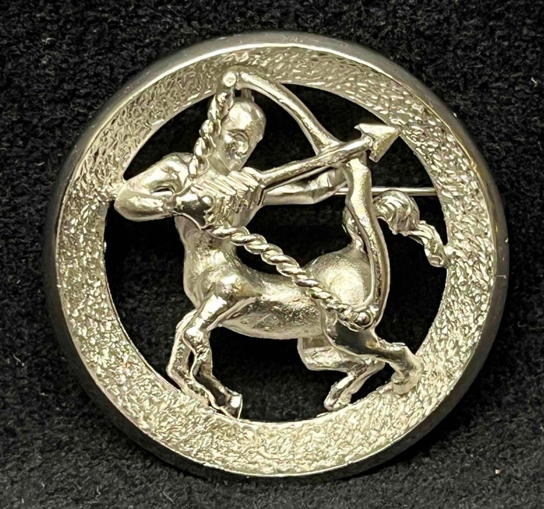 Vintage Signed Silver Tone Crown Trifari Sagittarius Zodiac Round Pin/Brooch: This lot contains a Vintage Signed Silver Tone Crown Trifari Sagittarius Zodiac Round Pin/Brooch. It is approx 1 1/2" x 1 1/2" x 1/2". Total weight is approx 0.5oz. Overall the Vintage Crown Trifari B
