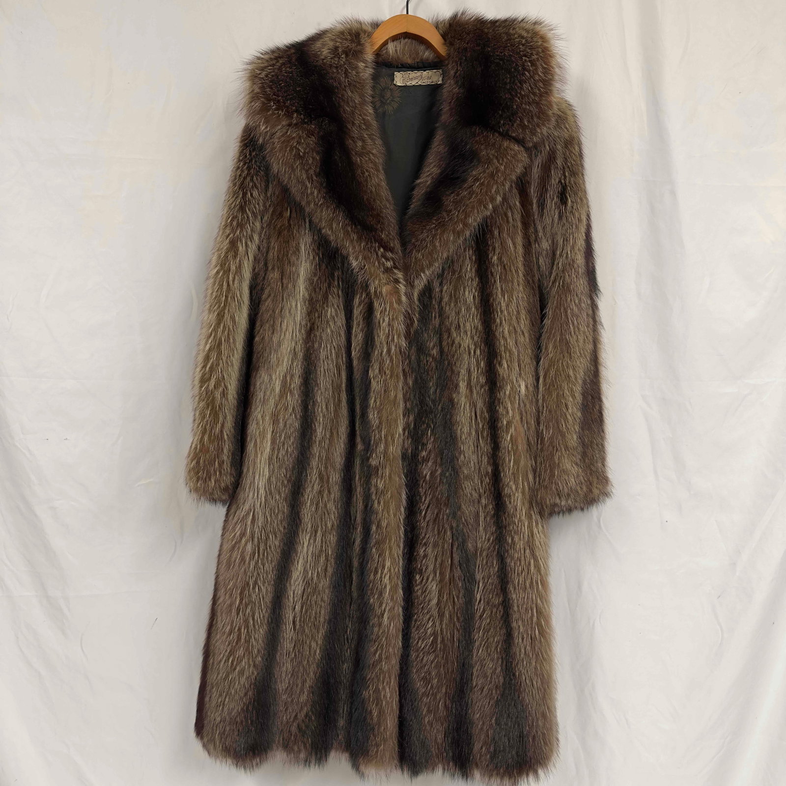 Michelson's Furs Brooklyn Monogram Personalized Fur Brown Raccoon Coat Long R120: Michelson's Furs Brooklyn Monogram Personalized Fur Brown Raccoon Coat Long R120. This coat features hook button closures. The interior is a black colored silk like material with floral design. Th