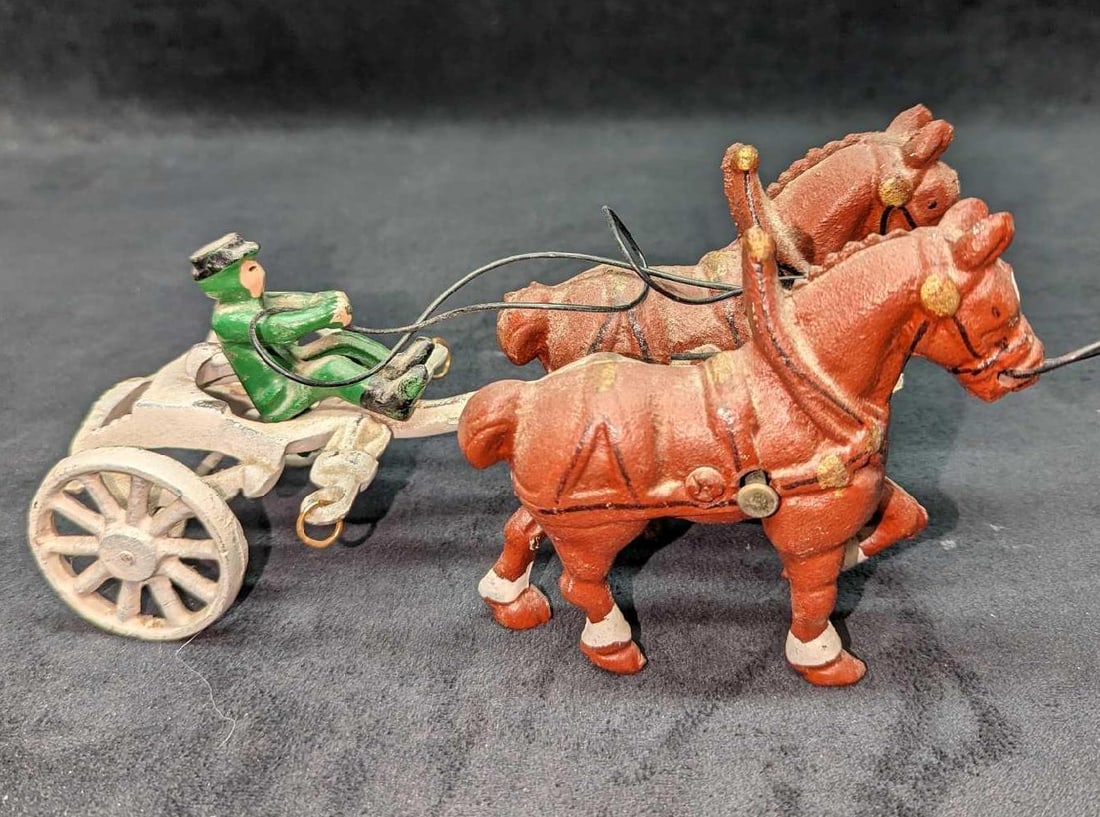Vintage Cast Iron Horse Carriage With Driver Toy: Vintage Cast Iron Horse Carriage With Driver Toy. This is approx 9" x 3 3/4" x 4 1/2" and it weighs 2.30lbs. The carriage toy has some color loss, and wear and one of the lead ropes is not attached to